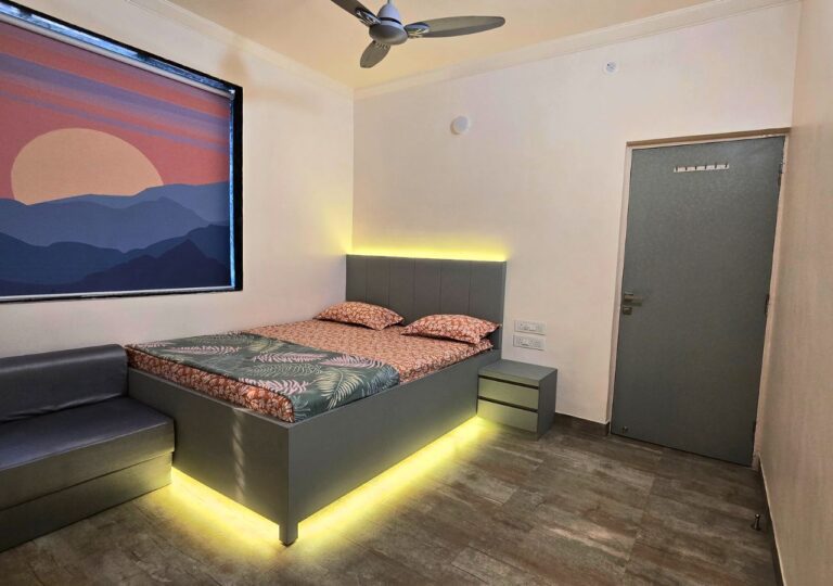 Vandana Villa, Alibag: AC bedroom with a bed, a sofa and a ceiling fan