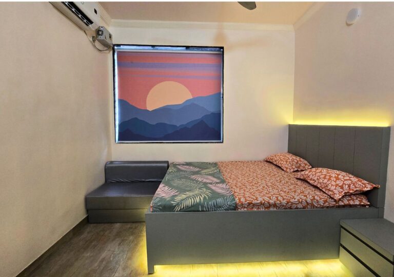 Vandana Villa, Alibag: AC bedroom with a sofa beside the bed