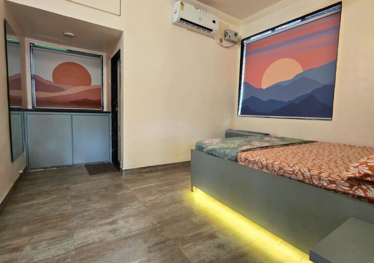 Vandana Villa, Alibag: AC bedroom with a wardrobe niche and a sunset print